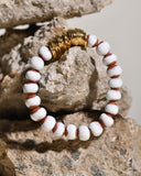 Bracelet with white and brown beads on a rock background