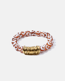 Beaded bracelet with orange and white pattern and gold clasp on a white background