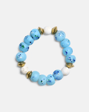 Bracelet with blue beads and gold accents on a white background