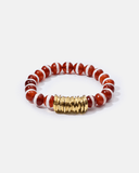 Bracelet with red and white beads and a gold clasp on a white background