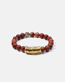 Bracelet with red beads and a gold clasp on a white background