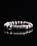 Bracelet with white and brown terracotta beads with silver spacers on a white background