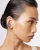 Close-up of a silver ear cuff on a white background