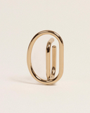 Gold ear-cuff with a unique design on a beige background