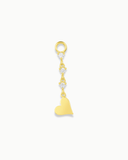 Gold charm with heart and white stones on a white background