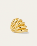 Gold ear cuff with wavy design on a light beige background