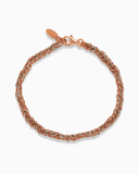 Grey and rose gold silk braided bracelet on a white background