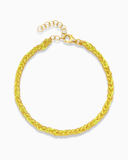 Neon yellow and gold silk braided bracelet on a white background