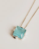 Necklace with a blue pendant on a light gray background