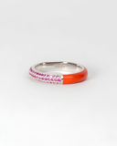Silver ring with pink stones and red-colored enamel band on a white background