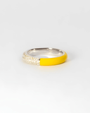 Silver ring with stones and yellow-colored enamel band on a white background