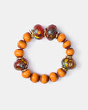 handmade artisan beaded Bracelet with orange and brown beads on a white background
