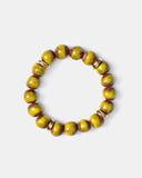 Green beaded bracelet with gold accents on a white background