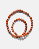 Beaded necklace with red and gold beads on a white background