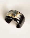 Black and gold natural horn cuff bracelet on a light background