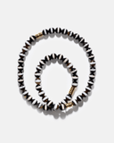 Black and white beaded necklace with gold accents on a white background