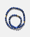 Blue beaded necklace with gold accents on a white background