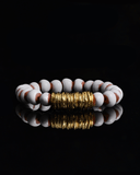 Bracelet with white and brown terracotta beads with gold spacers on a white background