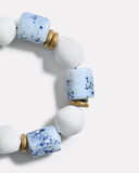 Bracelet with white beads and blue speckled beads on a white background