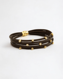 Brown leather bracelet with gold stones on a white background