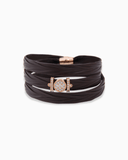 Brown leather wrap bracelet with a gold and rose gold clasp on a white background