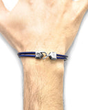 Blue leather bracelet with silver clasp on a wrist against a white background