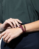 Close-up of a burgundy leather wrap bracelet on a wrist