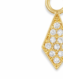 Close-up of a gold charm with embedded stones on a white background