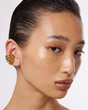 Close-up of a gold ear cuff on a white background