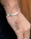 Close-up of a hand wearing a silver bangle bracelet
