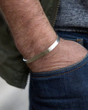 Close-up of a hand wearing a silver bangle bracelet