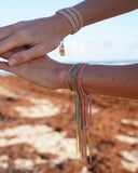 Close-up of a wrist with colorful silk tassel bracelets