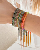 Close-up of a wrist with multicolored silk tassel bracelets