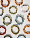 Colorful artisan beaded bracelets on a white background