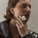 Woman wearing a large, colorful rings on their finger 