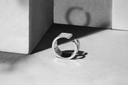 Silver ring on a textured surface with geometric background