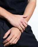Close-up of a man's hands with a gold ring on a plain background