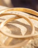 Gold bracelet on a reflective surface