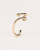 Gold ear-cuff on a light beige background