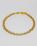 Gold chain necklace with an enamel clasp on a light gray background
