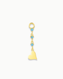 Gold charm with heart and blue stones on a white background