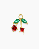 Gold cherry charm with red and green stones on a white background