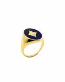 Gold pinky ring in blue enamel with center stone on a white background