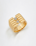 Gold ring with two stones on a light gray background