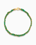 Green and gold silk braided bracelet on a white background