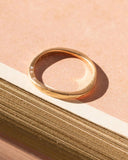 Gold ring on a textured beige surface