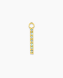 Long gold charm with blue stones on a white background
