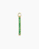 Long gold charm with green stones on a white background