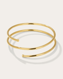 Mini gold bangle bracelet on a light gray background