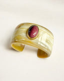 Natural horn cuff bracelet with a pink stone on a light background